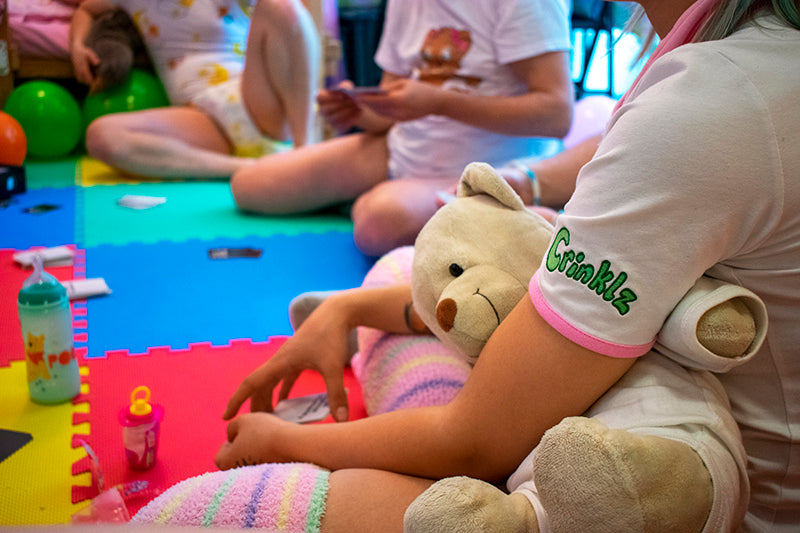 Adult littles at play at ABDL Playpen in Basel, Switzerland wearing Crinklz adult diapers.